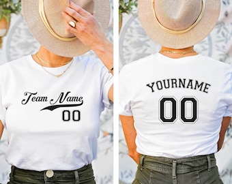 May include: White t-shirt with black text and a number on the front. The text says "Team Name 00". The back of the shirt has black text that says "YOURNAME 00".