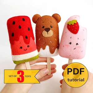 Könnte beinhalten: Set aus drei Filz-Eis-Spielzeugen. Die Eissorten sind Wassermelone, Schokoladenbär und Erdbeere. Die Spielzeuge sind handgefertigt und werden mit einem PDF-Tutorial geliefert. "Set of 3 Toys" und "PDF tutorial" sind auf dem Bild zu sehen.