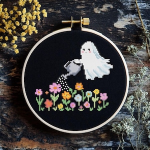 May include: A white ghost with a smiling face is watering a garden of colourful flowers with a grey watering can. The ghost is on a black background.
