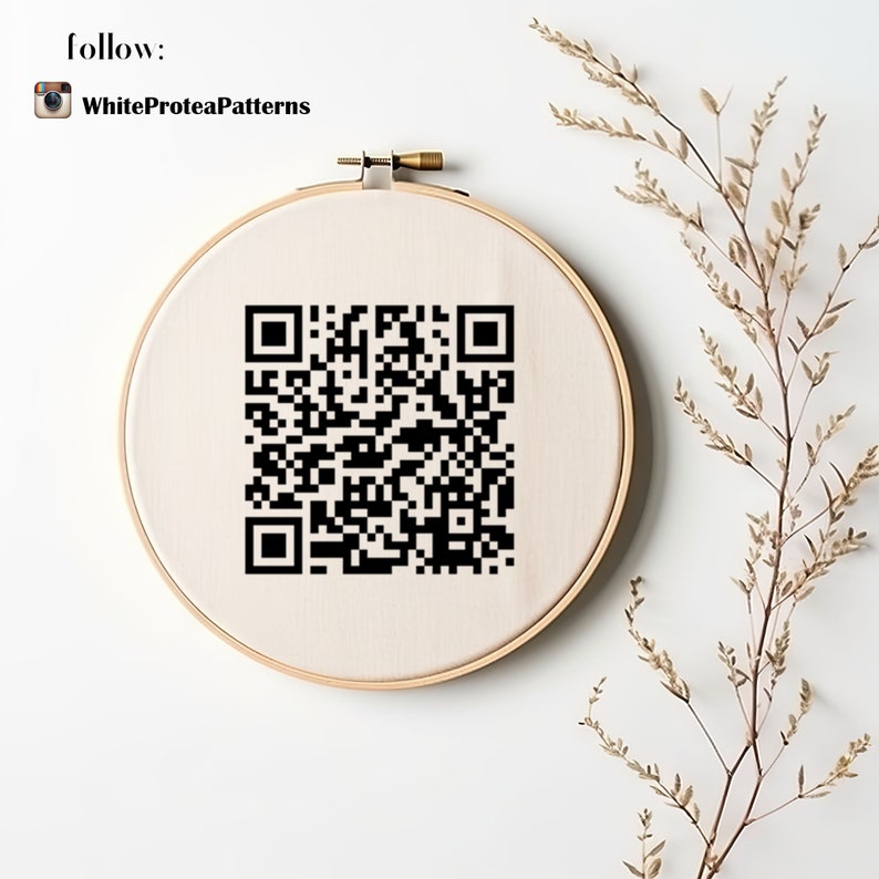 May include: A white embroidery hoop with a black and white QR code printed on the fabric. The hoop is on a white background with a dried branch of brown leaves.