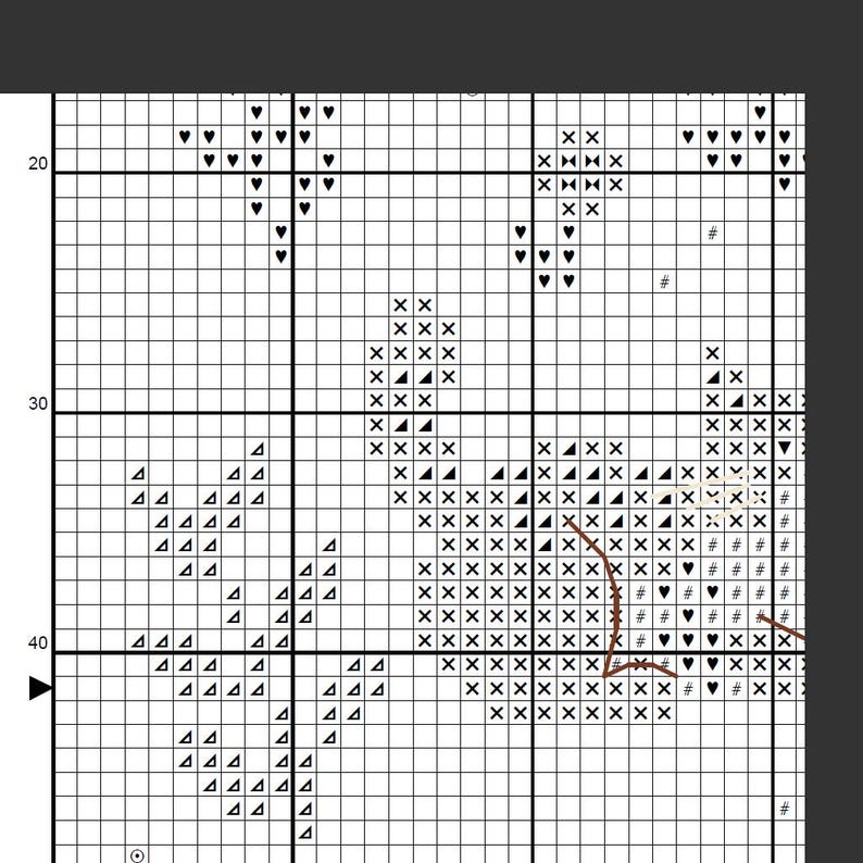 May include: A cross-stitch pattern chart with a grid of squares. The chart features symbols like hearts, triangles, and the letters "X" and "A", arranged to create a design. The pattern is in black and white.