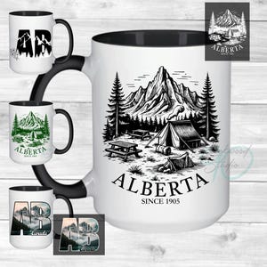 May include: White ceramic mug with a black interior and handle, featuring a black and white illustration of a mountain camping scene with the text "ALBERTA SINCE 1905". Additional mugs with similar designs are also shown.
