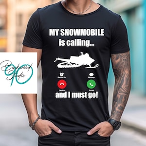 May include: Black t-shirt with a white graphic of a snowmobile with the text "My snowmobile is calling... and I must go!"