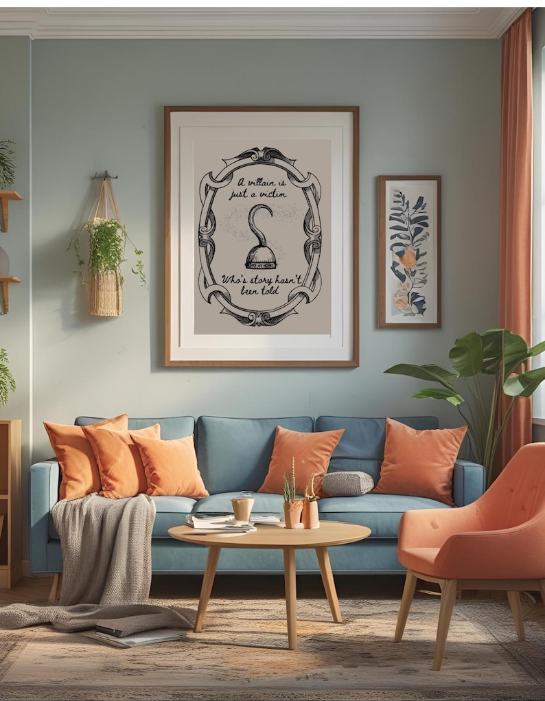 May include: A living room scene with a blue sofa, orange pillows, and a wooden coffee table. A framed print with the text "A villain is just a victim. Who's story hasn't been told" hangs above the sofa. An orange armchair sits nearby.