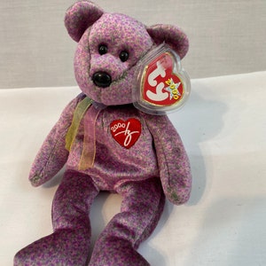 May include: Purple and green patterned Beanie Baby bear with a red heart tag that says "2000" and a Ty tag with a red heart and a star.