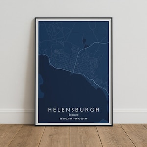 May include: A framed map print of Helensburgh, Scotland, featuring a dark navy blue background with light blue street lines. The text reads HELENSBURGH, Scotland, and the coordinates 56°00'22" N / 04°43'35" W in a clean white sans-serif font.
