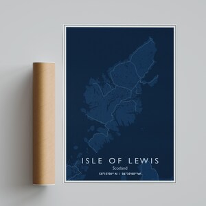 May include: A dark blue map print of the Isle of Lewis, Scotland, featuring white outlines of the island's geography. The text reads ISLE OF LEWIS, Scotland, and the coordinates 58°15'00" N / 06°30'00" W. A brown cardboard mailing tube is adjacent.