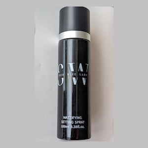 Puede incluir: Una botella negra de spray fijador matificante Skin Wise Labs. La botella está etiquetada con el nombre de la marca y el nombre del producto. La botella contiene 100 ml o 3,38 fl. oz.