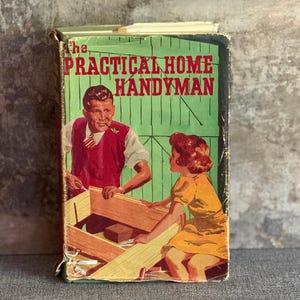 May include: A vintage book cover for "The Practical Home Handyman." The illustration shows a man and a girl building a wooden structure. The man wears a red waistcoat, and the girl is in a yellow dress. The background is green.