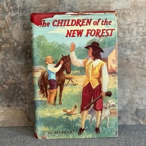 May include: A vintage book cover for "The Children of the New Forest" by Capt. Marryat. The cover shows a colourful illustration of a man in a hat, holding a rifle, with a dog, a horse, and a young person. The book has a red spine.
