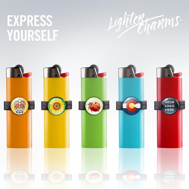 May include: Five different colored lighters with interchangeable charms. The charms include a sugar skull, a sunflower, a ladybug, a Colorado flag, and a customizable logo. The lighters are all silver and have a black plastic ring around the middle. The text "Lighter Charms" is written in cursive at the top of the image.