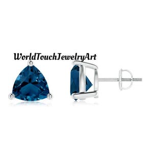 May include: A pair of silver stud earrings with a triangular blue gemstone in each earring. The earrings have a screw-back closure.