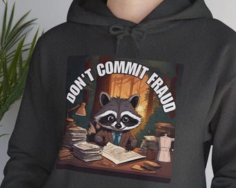 Peut inclure: Sweat à capuche gris foncé avec un motif de raton laveur en costume et le texte "DON'T COMMIT FRAUD". Le raton laveur est assis à un bureau avec des papiers. Le motif est imprimé sur le devant du sweat à capuche.