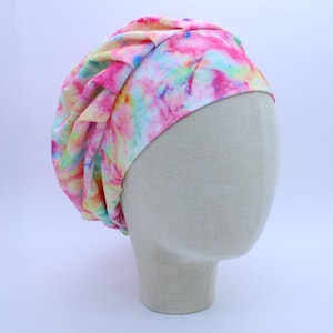 May include: A pink, yellow, and blue tie-dye surgical scrub hat with a gathered top.