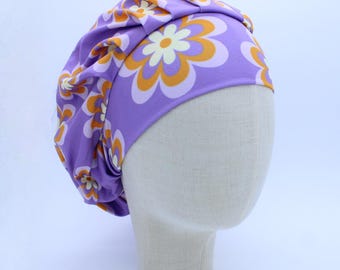 May include: Purple satin sleep cap with a retro floral print featuring orange and white flowers.