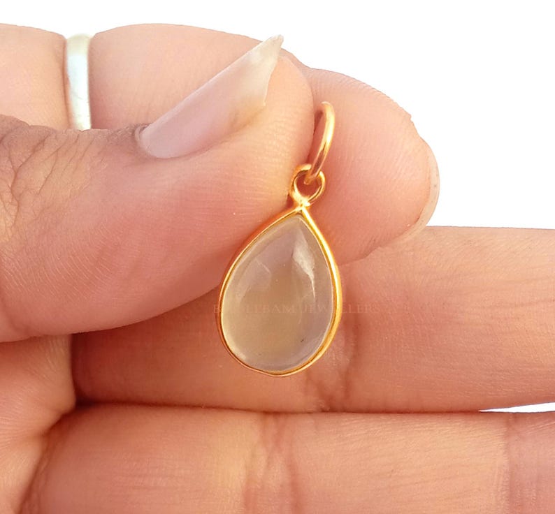 May include: A gold pendant with a clear teardrop-shaped gemstone.
