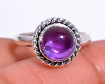 May include: A silver ring with a purple amethyst gemstone set in a twisted rope design.