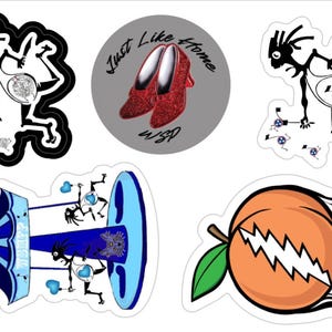 Puede incluir: Una colección de pegatinas con varios diseños. Una pegatina presenta zapatos rojos brillantes con el texto "Just Like Home". Otras pegatinas incluyen figuras de dibujos animados, un carrusel y un melocotón con una calavera.