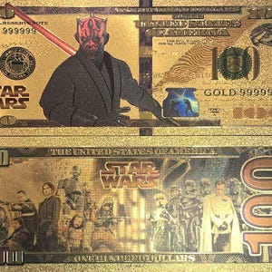 May include: A gold-colored paper bill with a Star Wars theme. The front features Darth Maul, a red-skinned character with horns, and the text "GOLD 999999". The back features a group of Star Wars characters, including Darth Vader, Stormtroopers, and a Jedi.