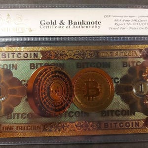 Peut inclure: Un certificat d'authenticité doré pour un billet de banque Bitcoin. Le certificat est dans une pochette en plastique et porte le texte "Gold & Banknote Certificate of Authenticity" et "99.9 Pure 24k Carat Gold".