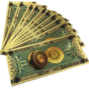 Peut inclure: Une pile de billets de banque de couleur or avec le mot "Bitcoin" imprimé dessus. Les billets présentent un fond vert avec une image stylisée d'une pièce de monnaie Bitcoin.