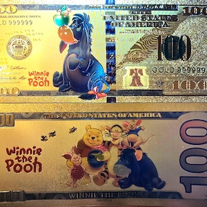 May include: A gold-coloured paper note featuring Winnie the Pooh characters. The note depicts a portrait of Winnie the Pooh and Piglet on the front and a group of Winnie the Pooh characters on the reverse. The note has the text "GOLD 999999" and "100" printed on it.