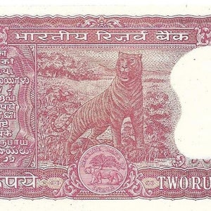 May include: A pink and white two rupee banknote from India featuring a tiger in a jungle setting. The text on the note reads "भारतीय रिज़र्व बैंक" and "TWO RUPEES".