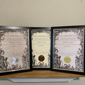 May include: Three black framed certificates with ornate gold and silver seals. Each certificate reads "Soul Certificate" and includes the text "Whoever is in possession of this certificate hereby owns the soul of INSERT NAME".