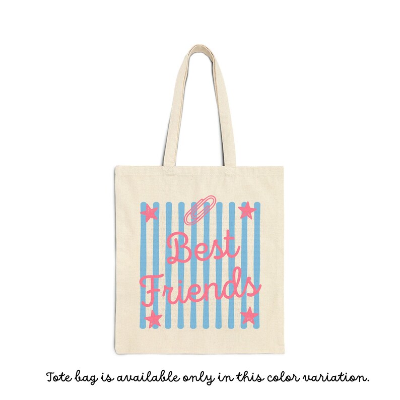May include: A beige canvas tote bag featuring a central graphic of vertical light blue stripes. Overlaid on the stripes is the pink text "Best Friends" in a cursive script, accompanied by a pink paperclip icon and four pink stars.