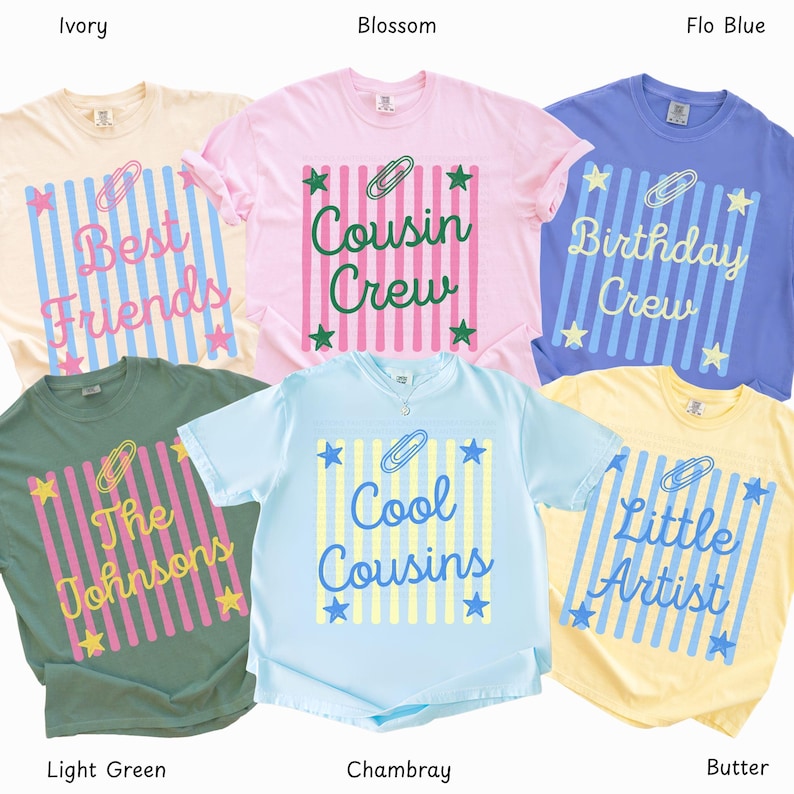 May include: Six short-sleeve t-shirts in ivory, blossom, flo blue, light green, chambray, and butter colors. Each shirt features a central graphic with vertical stripes, a paperclip icon, star accents, and text including Best Friends, Cousin Crew, Birthday Crew, The Johnsons, Cool Cousins, and Little Artist.