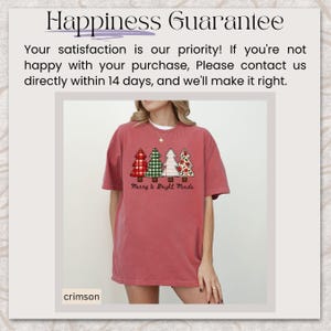 May include: Crimson-colored t-shirt featuring a graphic of four Christmas trees in red plaid, green gingham, white, and floral patterns. The text "Merry & Bright Minds" is below the trees. The shirt is part of a clothing collection.