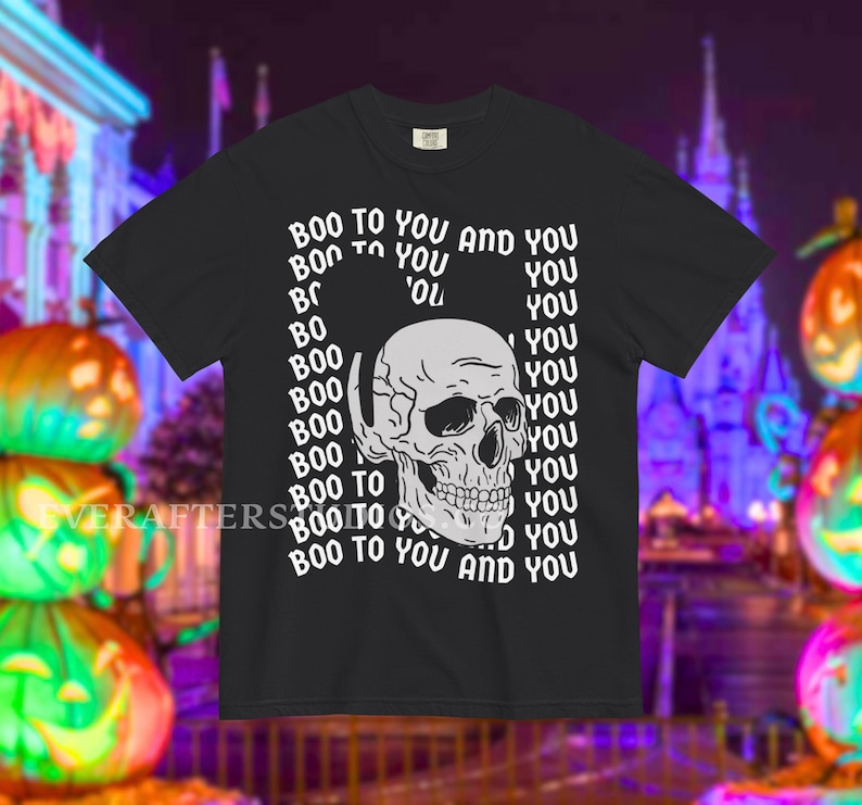 Może przedstawiać: Czarny t-shirt z kr&oacute;tkim rękawem z białą grafiką ludzkiej czaszki umieszczoną na środku klatki piersiowej. Tekst "BOO TO YOU AND YOU" jest powt&oacute;rzony w pionowym, falistym wzorze otaczającym czaszkę pogrubioną, białą czcionką bezszeryfową.