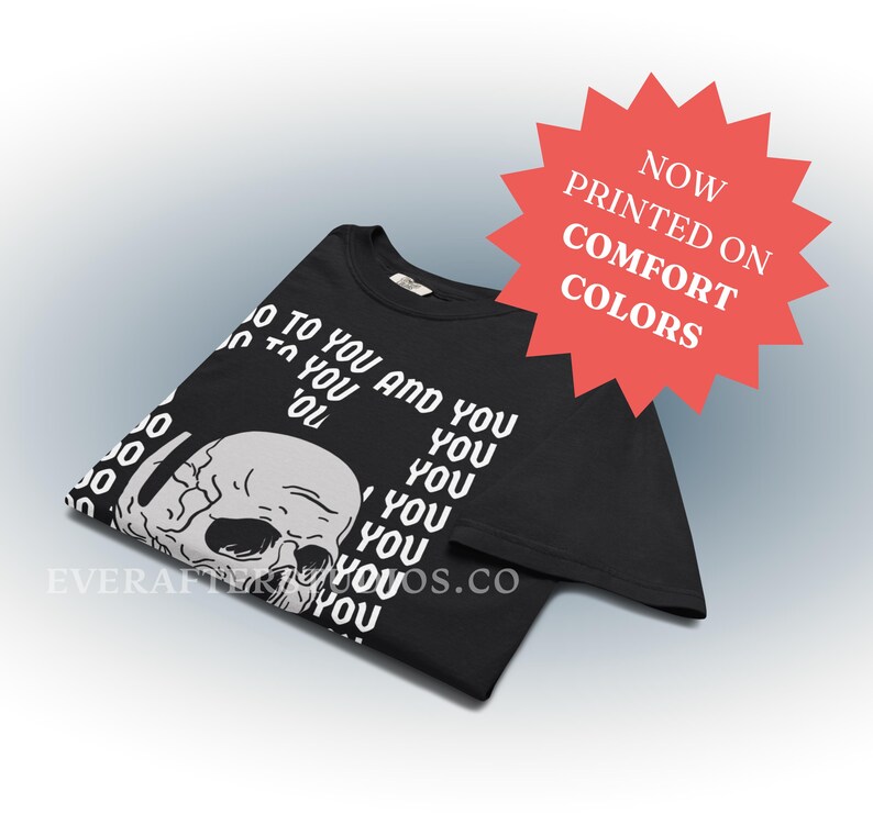 Może przedstawiać: Czarny t-shirt z białą grafiką ludzkiej czaszki i powtarzającym się tekstem 'YOU' w kolumnie, wraz z napisem 'NOW PRINTED ON COMFORT COLORS' w czerwonej gwiazdce oraz adresem strony internetowej 'EVERAFTERSTUDIOS.CO'.