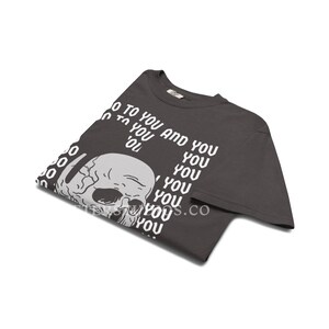 Może przedstawiać: Ciemnoszary t-shirt z kr&oacute;tkim rękawem z białą grafiką ludzkiej czaszki w lewej dolnej części. Tekst "TO YOU AND YOU" jest nadrukowany na biało w powtarzającym się wzorze wok&oacute;ł czaszki, przy czym słowo "YOU" jest powt&oacute;rzone wielokrotnie.