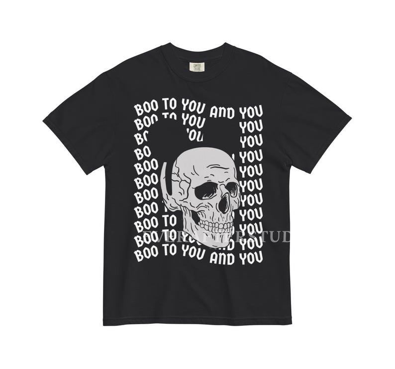 Może przedstawiać: Czarny t-shirt z kr&oacute;tkim rękawem z centralną białą grafiką przedstawiającą ludzką czaszkę. Tło grafiki składa się z powtarzającego się białego napisu "BOO TO YOU AND YOU" ułożonego w falisty, zniekształcony wz&oacute;r wok&oacute;ł czaszki.