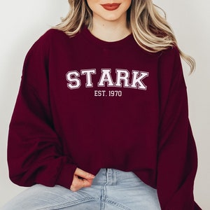 May include: Burgundy sweatshirt with white text that reads "STARK EST. 1970".