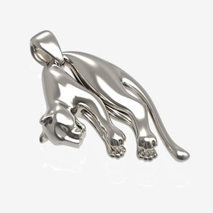 Puede incluir: Un colgante de plata con forma de pantera agazapada. La pantera est&aacute; detallada con una superficie texturizada y tiene un bucle en la parte superior para sujetarlo a una cadena.