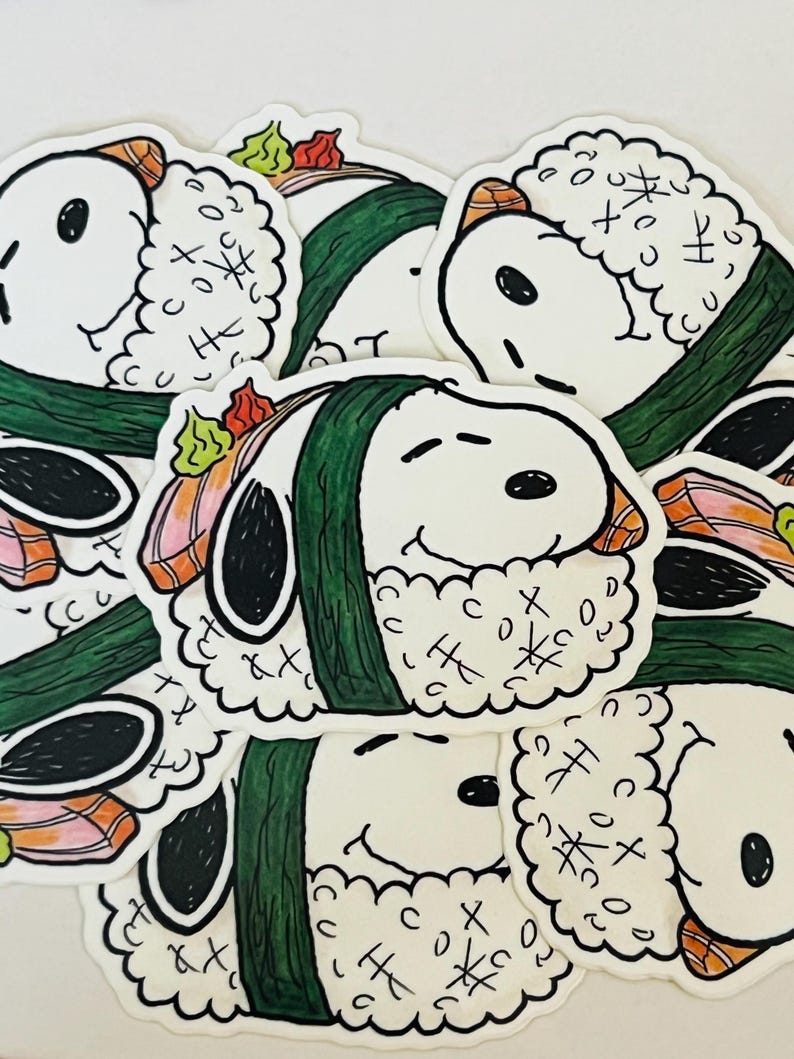 May include: A collection of stickers featuring a cartoon character designed as sushi. The stickers have a white background with a smiling face, green seaweed, and sushi toppings. The stickers are a fun, whimsical design.