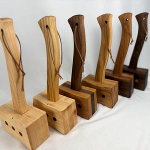 Puede incluir: Seis mazos de madera con diferentes tonos. Cada mazo tiene una cabeza rectangular y un mango curvo con un lazo de cuero. Los colores de la madera varían de marrón claro a oscuro.