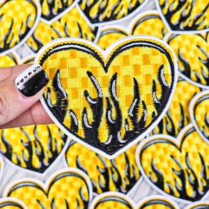May include: A set of yellow and black heart-shaped patches with flames. The hearts have a checkered pattern.