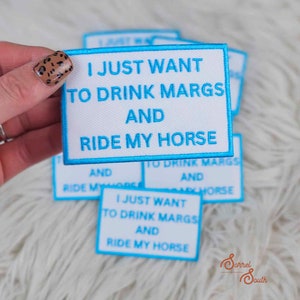 May include: White iron-on patch with blue text that reads "I just want to drink margs and ride my horse".