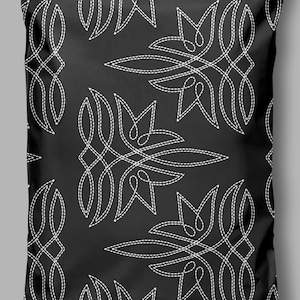 Könnte beinhalten: Schwarzer Kissenbezug mit einem sich wiederholenden Muster aus weiß gestickten floralen und geometrischen Designs. Der Kissenbezug hat eine glatte, leicht glänzende Textur. Das Design zeigt stilisierte Blumen und abstrakte Formen.