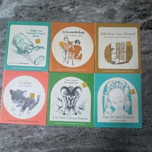 Pode incluir: Seis livros de leitura espanhóis vintage com capas coloridas. Os títulos incluem "Philip Y Las Noventa Y Nueve Ranas" e "La Vacación De Randy." Cada livro apresenta ilustrações e texto, com o título da série "A Spanish Readingtime Book."