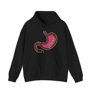 May include: Black hoodie with a graphic of a skeleton relaxing inside a pink human stomach.