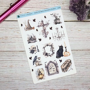 May include: Decorative sticker sheet featuring Halloween-themed illustrations. Includes a witch's hat, a skull, a black cat, a pumpkin, a cross, a chandelier, a raven, a coffin, and a haunted house. The text "snowdrop + sassafraz" and "Quoth the Raven Decorative Stickers" are visible.