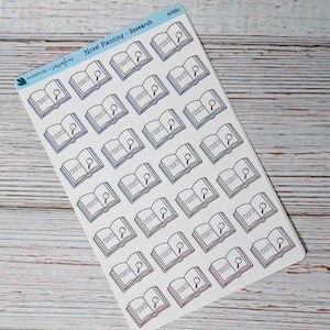 May include: A sheet of stickers featuring open books with the word "research" and a magnifying glass. The stickers have a gradient color scheme, with shades of blue, green, and pink. The text "Novel Planning - Research" is at the top.