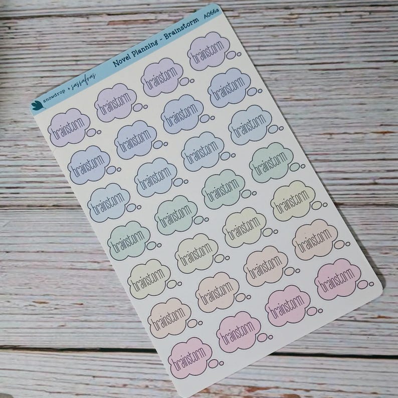May include: A sheet of planner stickers featuring the word "brainstorm" inside pastel-colored thought bubbles. The stickers are labeled "Novel Planning - Brainstorm" and include the brand name "snowdrop + passaflores".