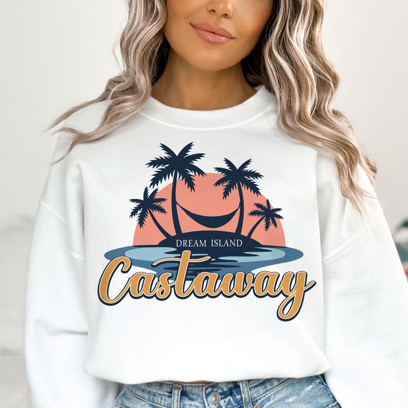 May include: White sweatshirt with a graphic of palm trees, a hammock, and a sunset. The text "Dream Island Castaway" is printed below the graphic.