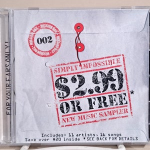 May include: A white CD case with a red and black stamp that says "Simply Impossible $2.99 or Free New Music Sampler". The case has a red string with two red plastic buttons. The text "For Your Ears Only!" is printed on the side of the case.