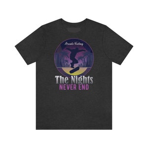 May include: Dark heather grey t-shirt with a retro-style graphic of a person skateboarding in front of palm trees. The graphic has a purple and pink color scheme and the text "Arcade Feeling" and "The Nights Never End".
